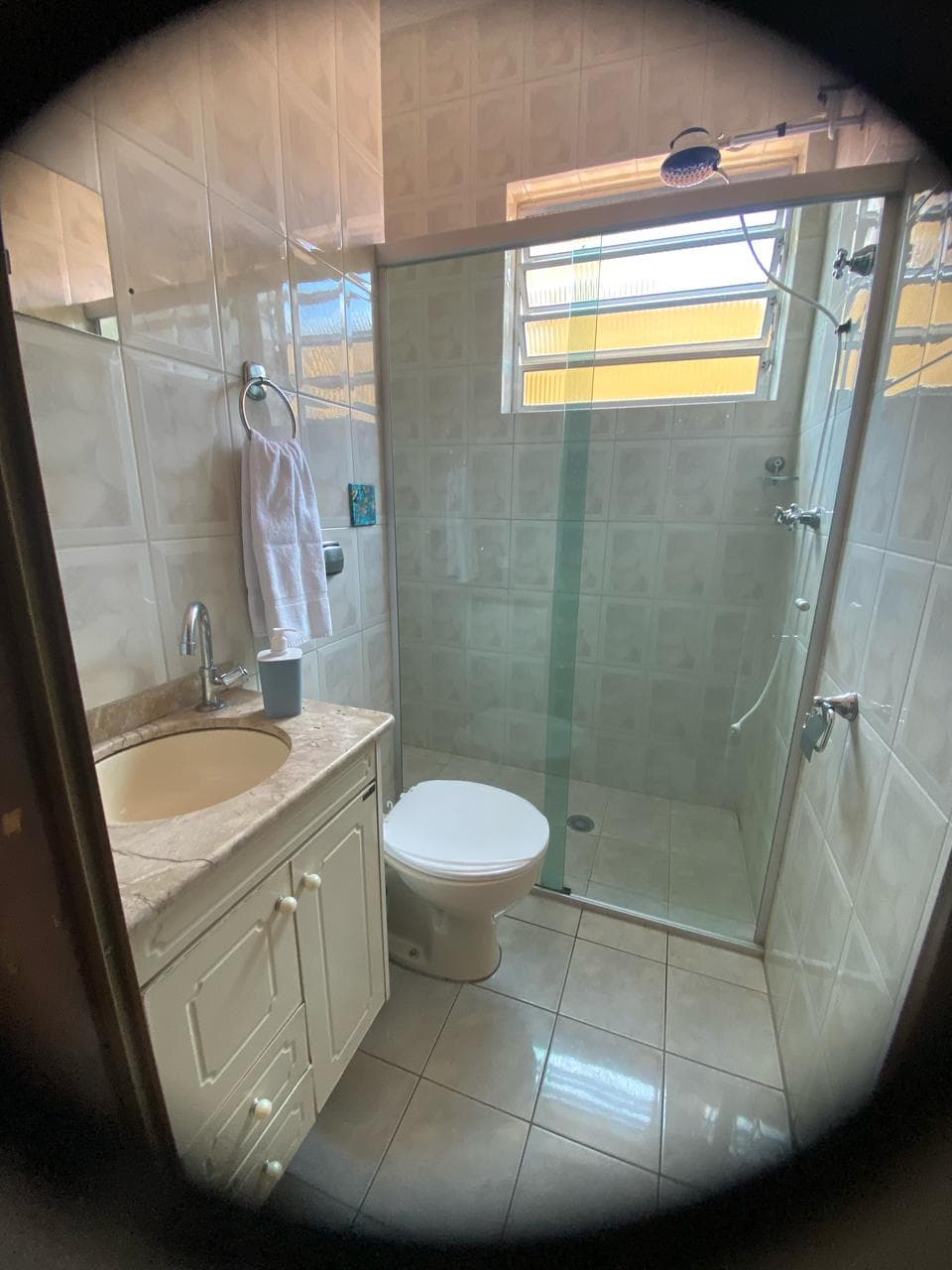 Banheiro bem iluminado com pia e espelho grande