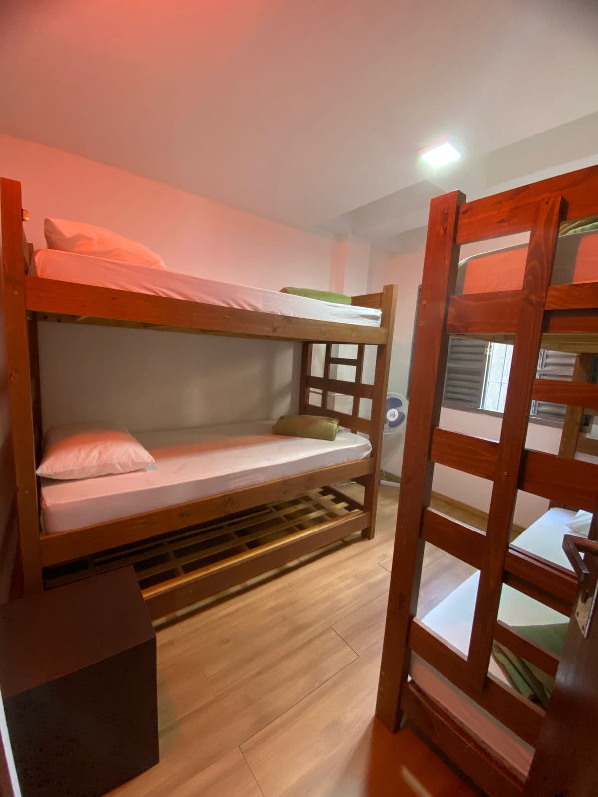 Quarto coletivo com beliches e janelas grandes