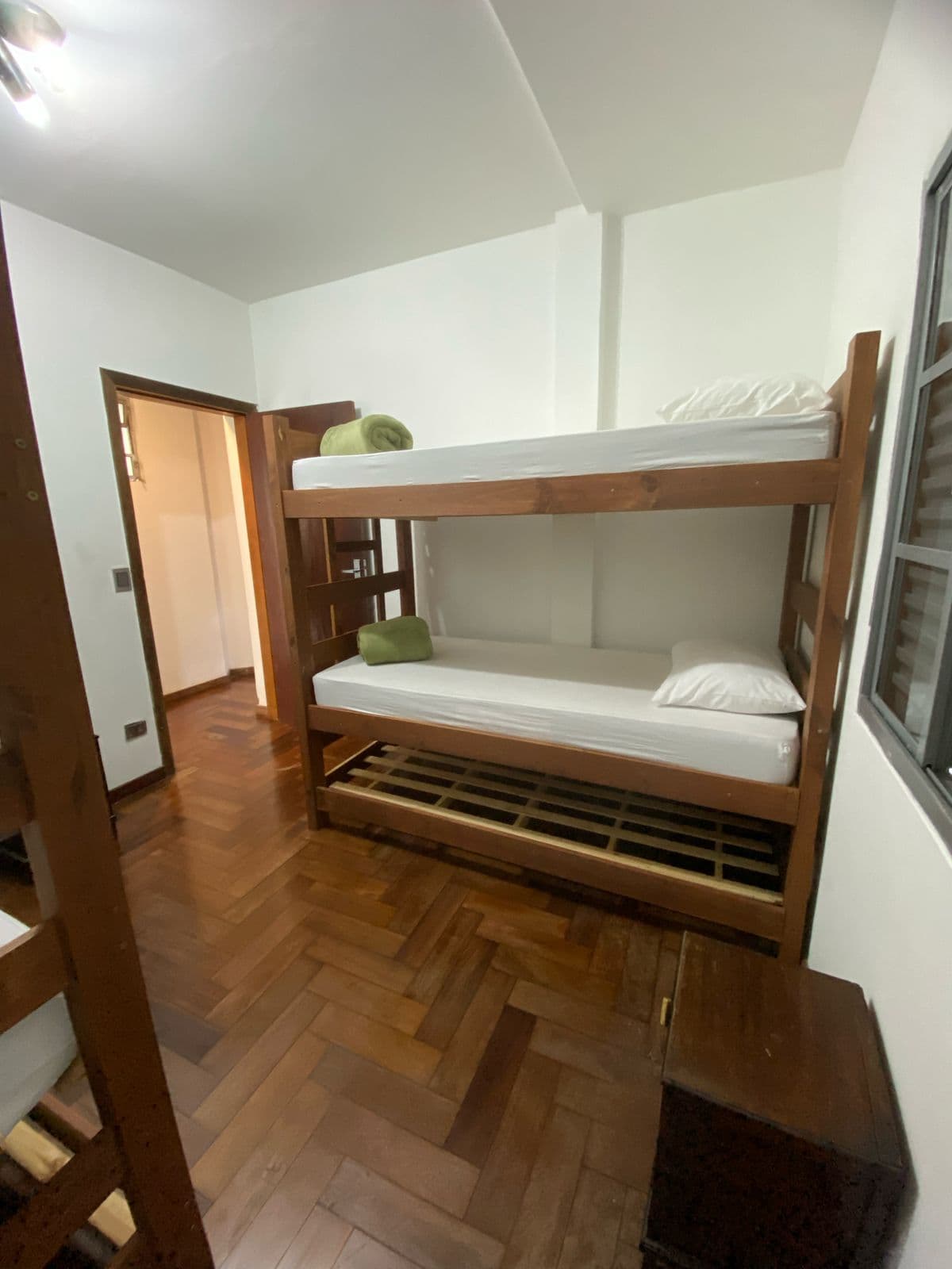 Quarto coletivo com múltiplas camas e ventilação natural