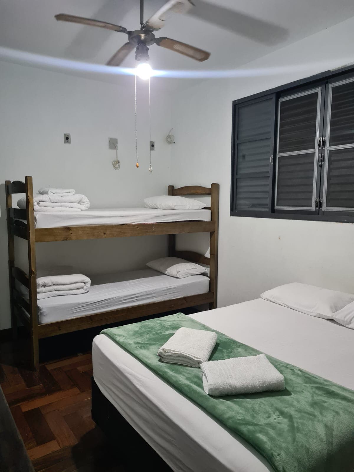 Quarto com beliches e iluminação agradável