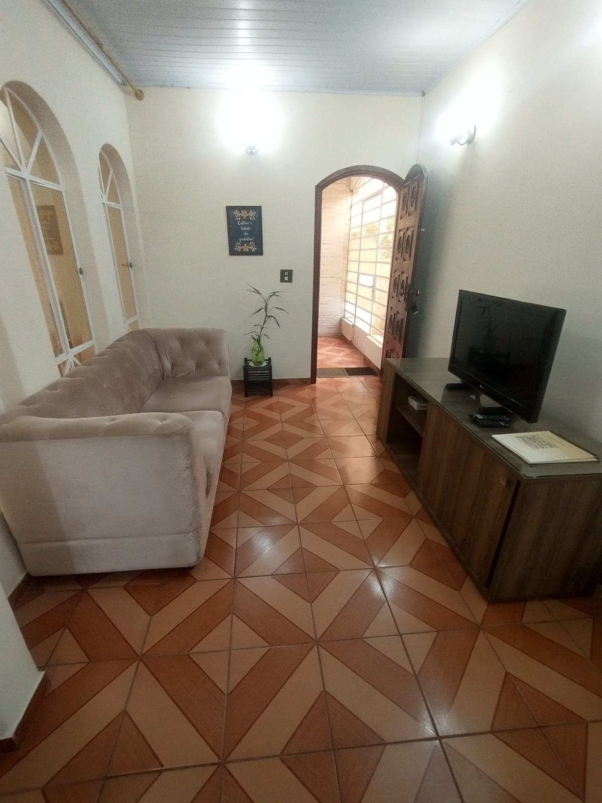 Sala de TV com sofás e cortinas