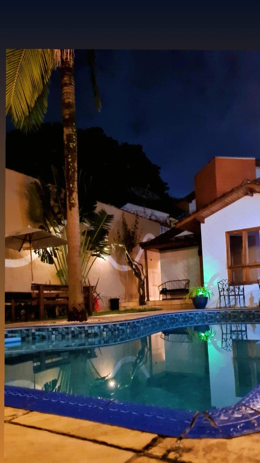Piscina iluminada à noite com atmosfera sofisticada