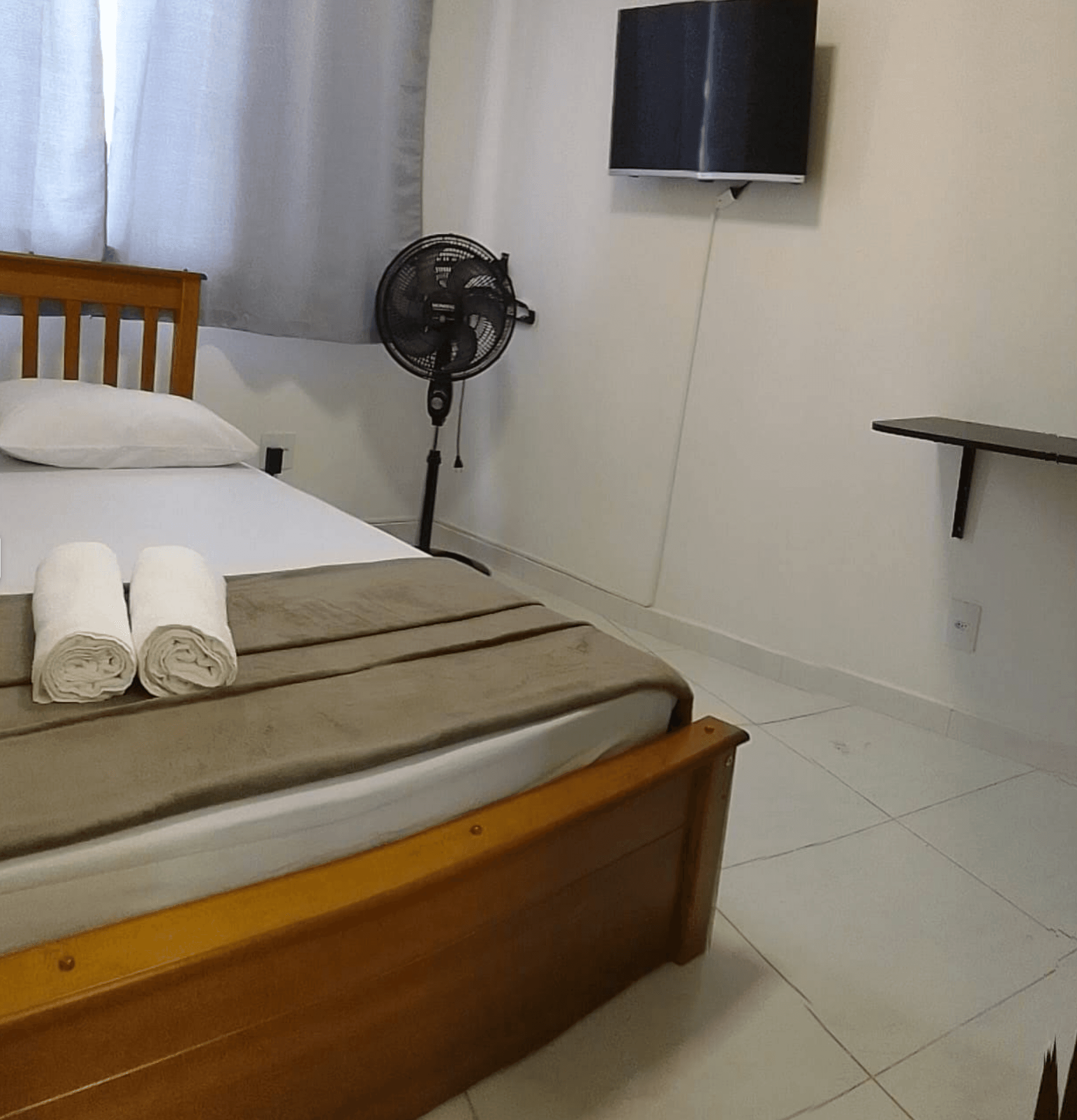 Quarto iluminado com cama e mesa lateral