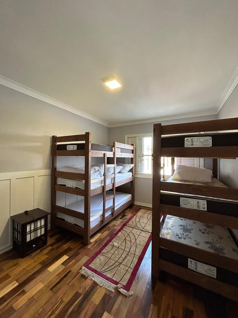 Dormitório compartilhado com beliches de madeira e ambiente acolhedor