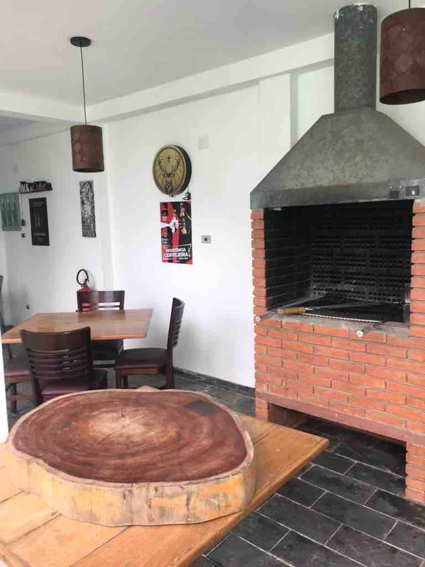 Área externa com churrasqueira e mesa para o grupo
